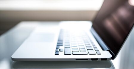 Free Elegant side view of a laptop on a glossy table with natural lighting indoors. Stock Photo